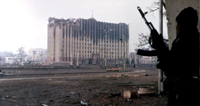Ein tschetschenischer Kämpfer vor dem zerstörten Regierungsgebäude in Grosny (Januar 1995) | Wikipedia | Mikhail Evstafiev | CC BY-SA 3.0 